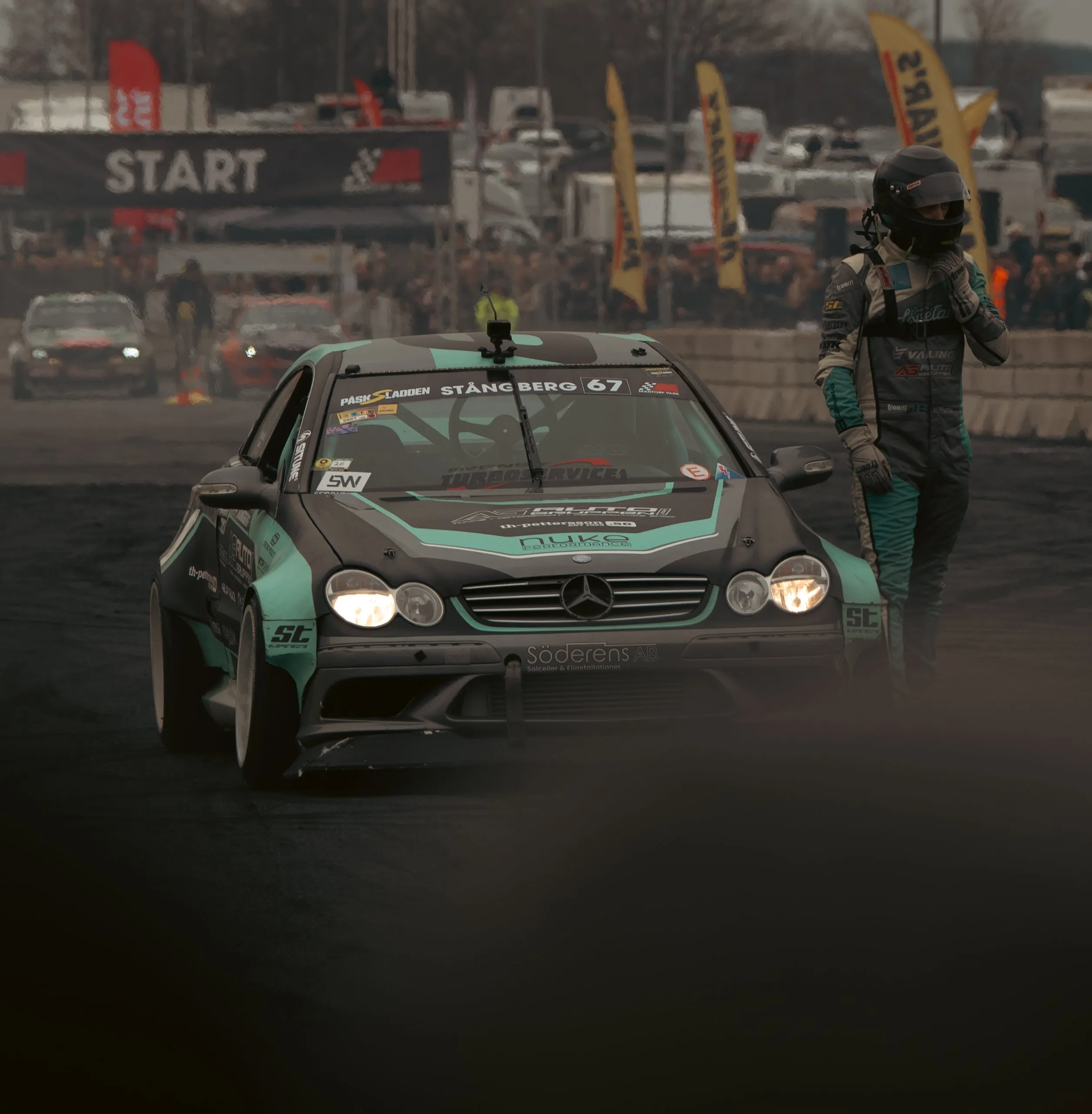 Mercedes CLK drift car at the start line with the driver beside it