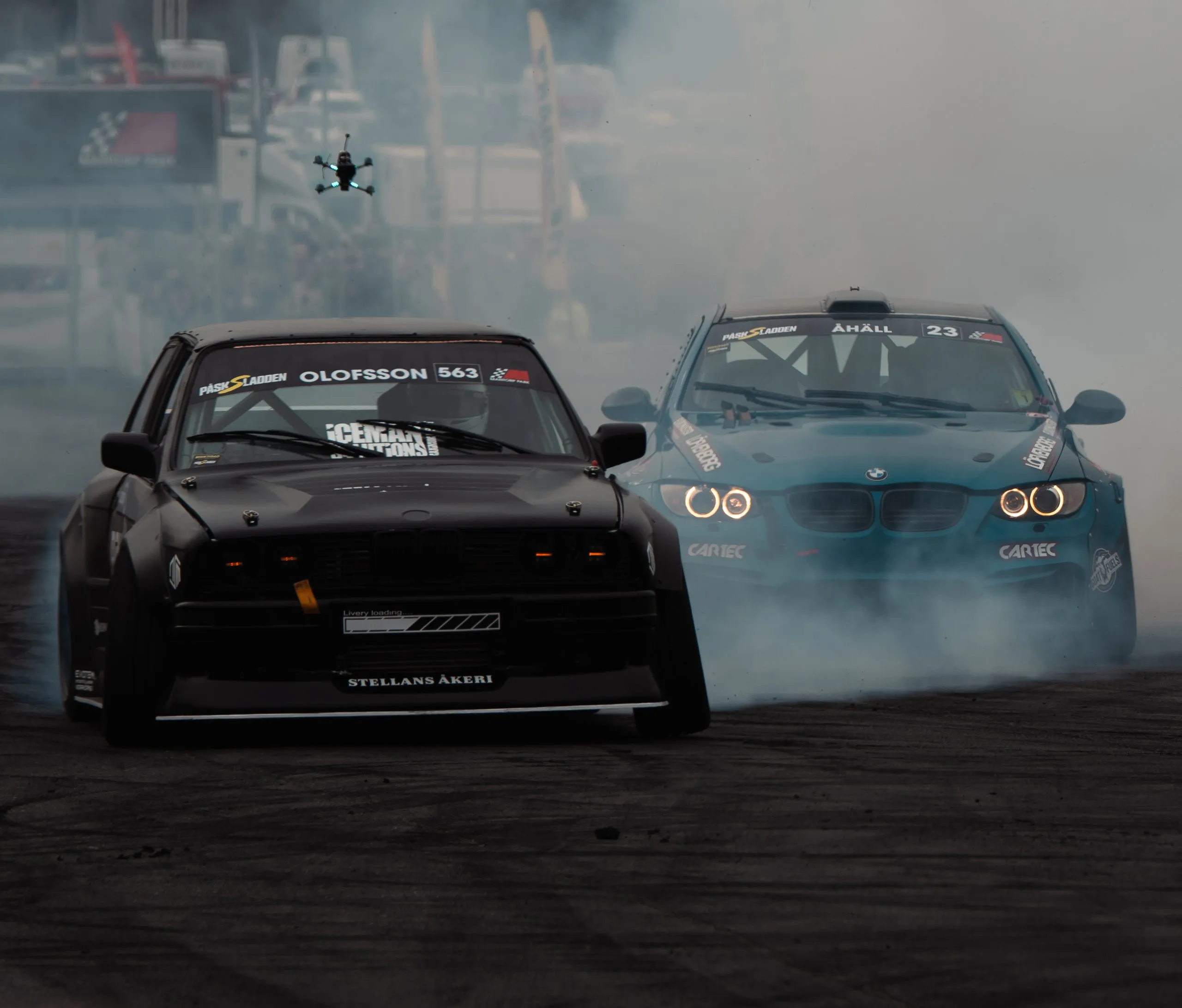 Black BMW E36 and blue BMW drifting towards the camera