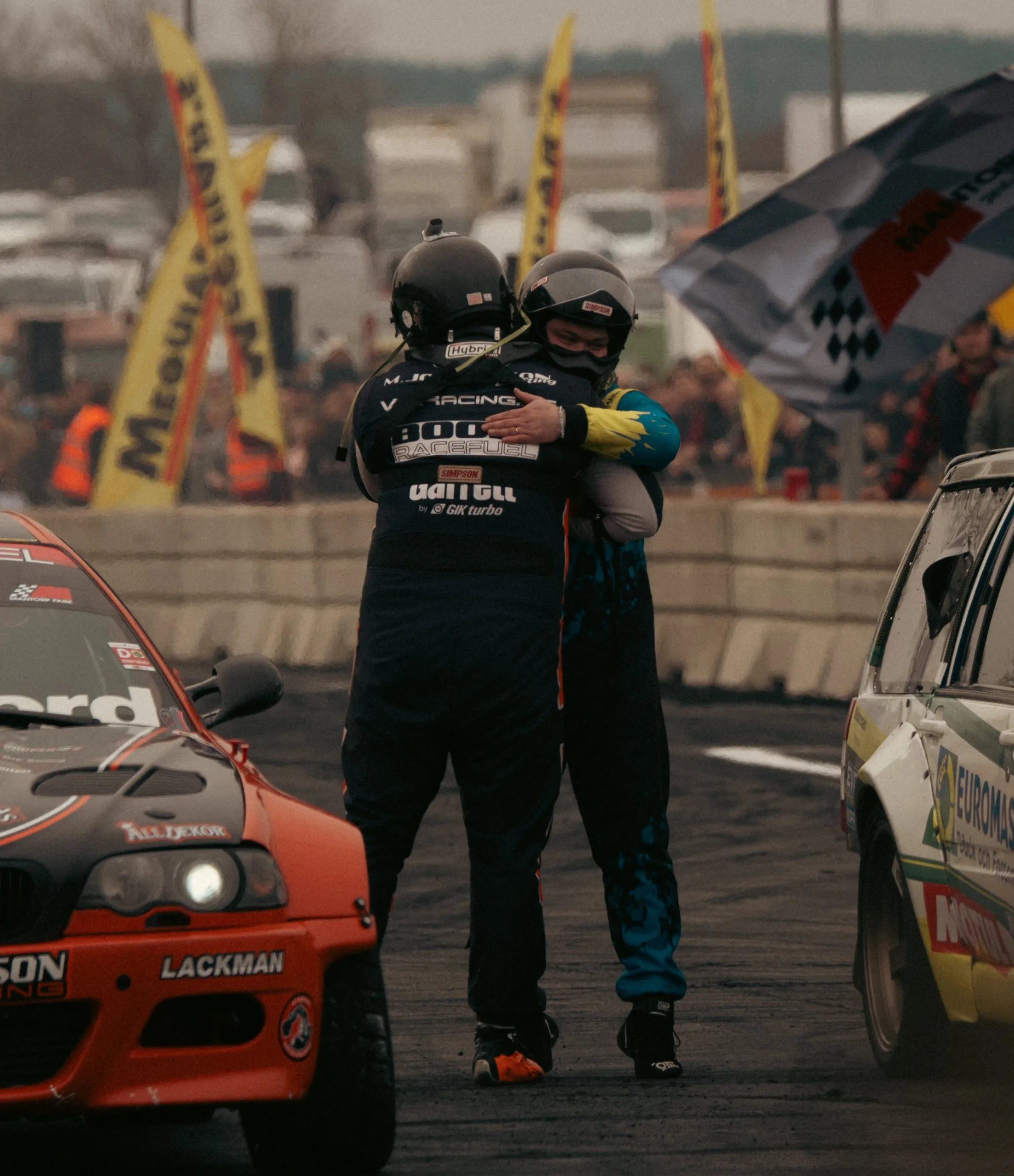 Two drift drivers hugging after a heat