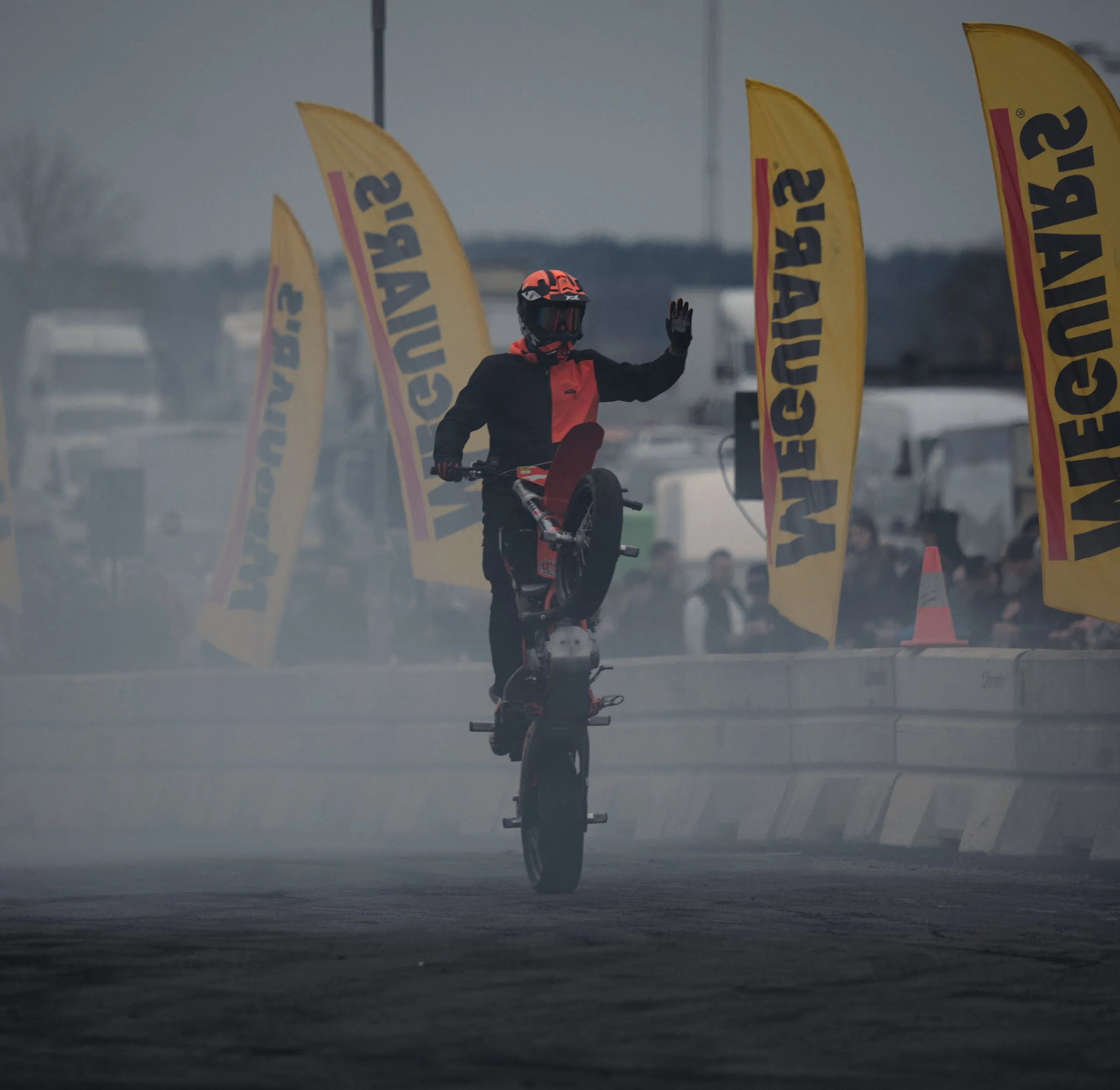 Stunt rider standing on a KTM and waving to the crowd