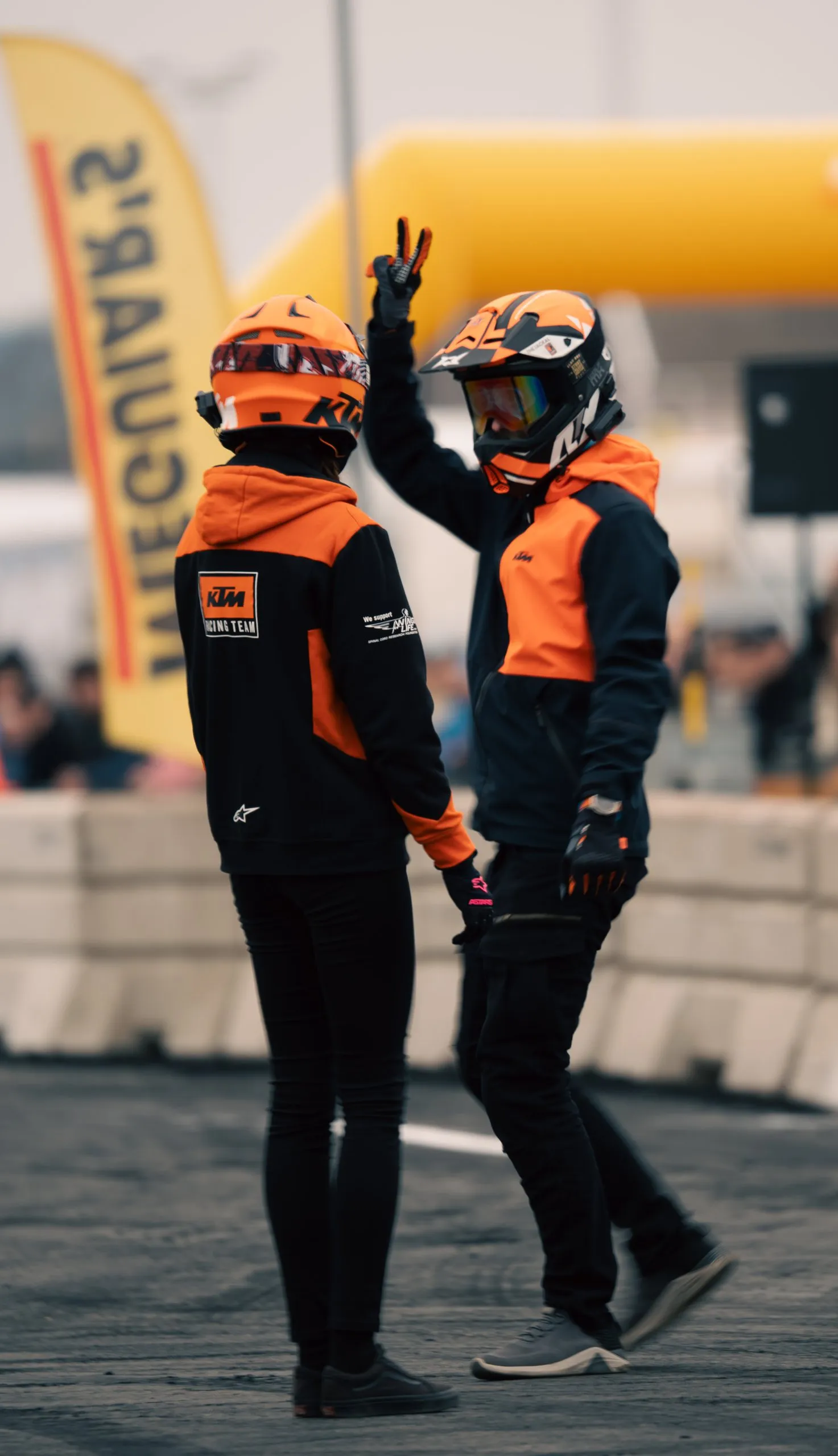 Two motorcycle stunt riders doing a high five