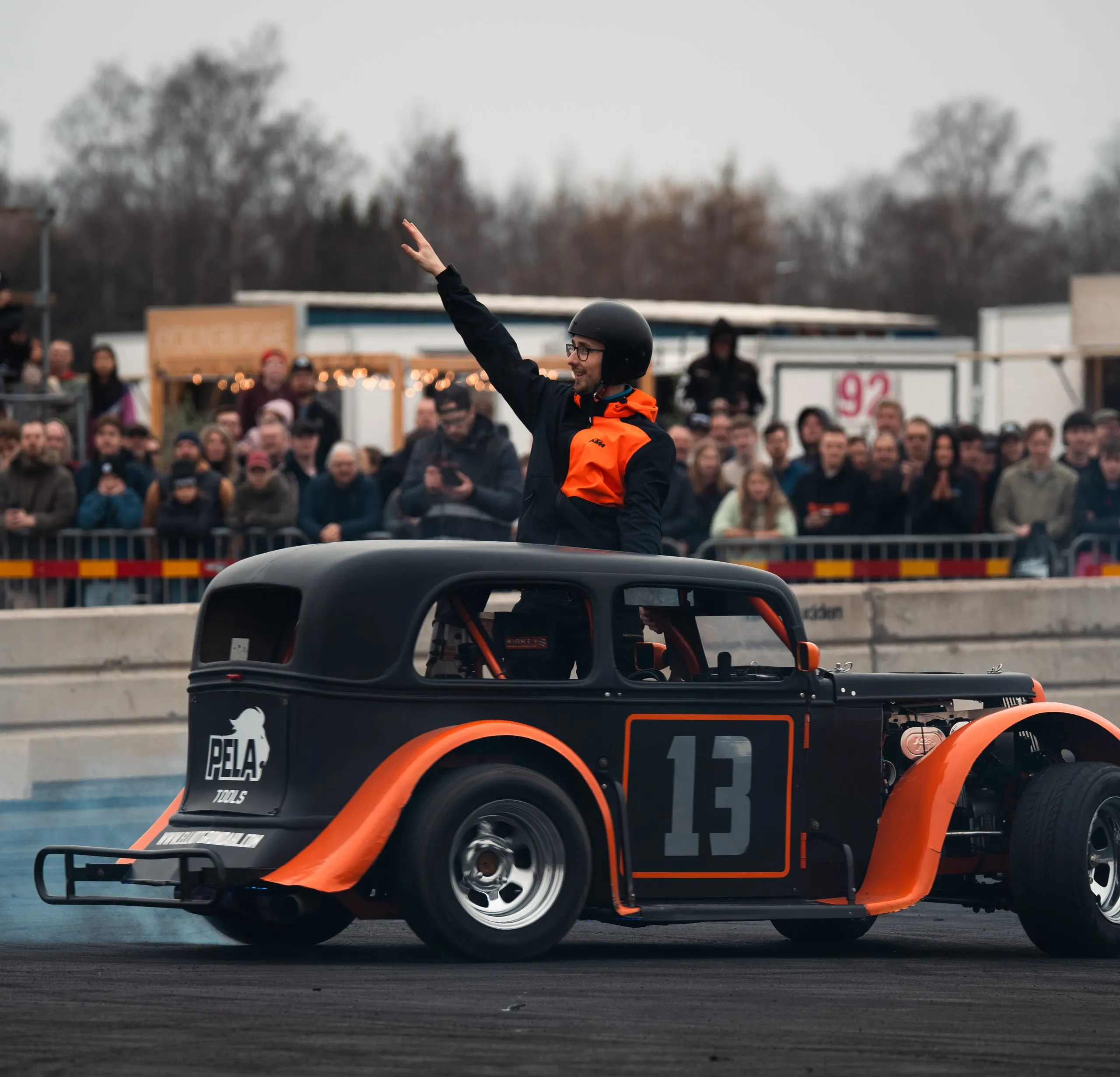 Driver of hot rod number 13 waving to the crowd