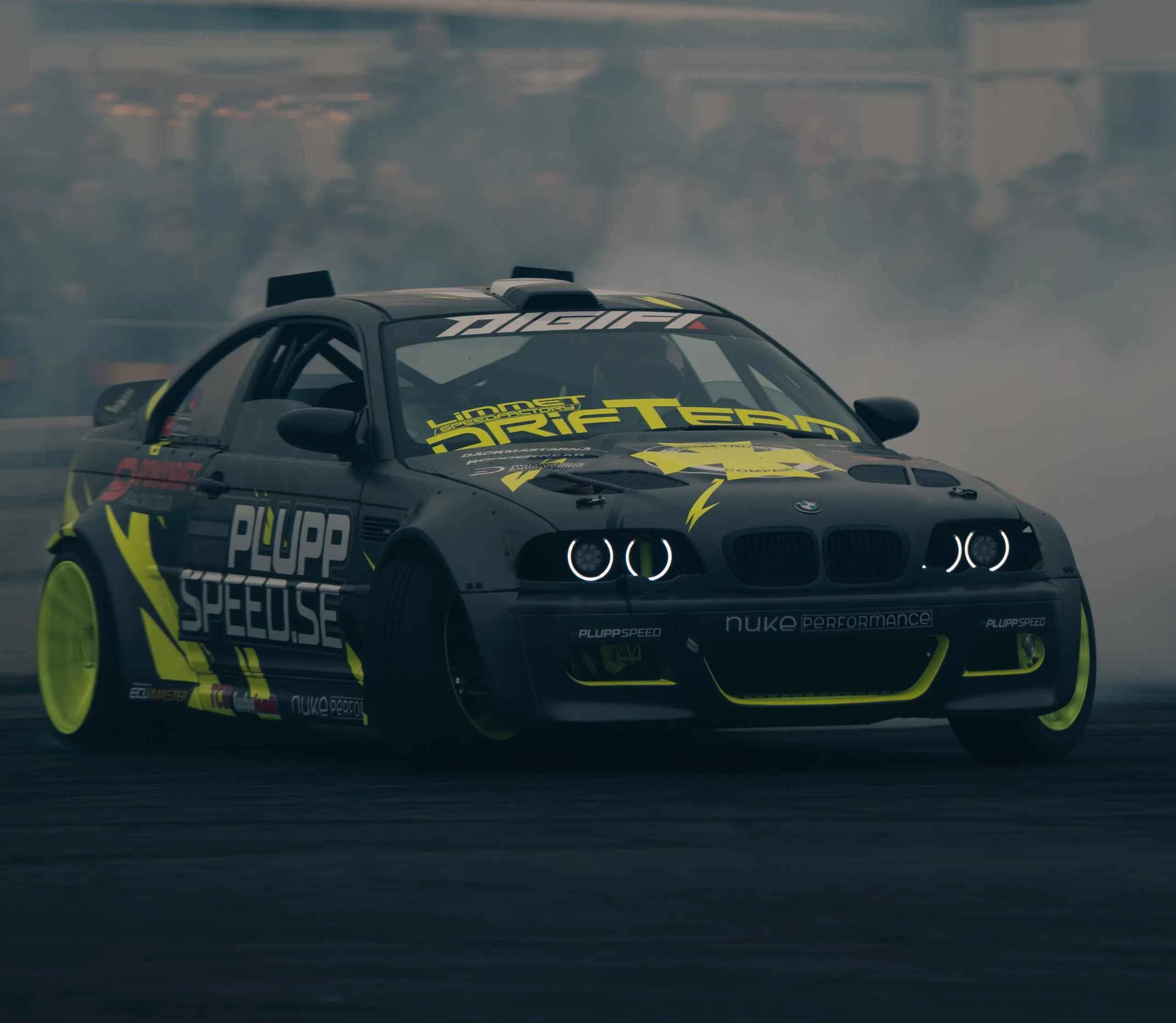 Black and yellow BMW E46 drift car in the smoke