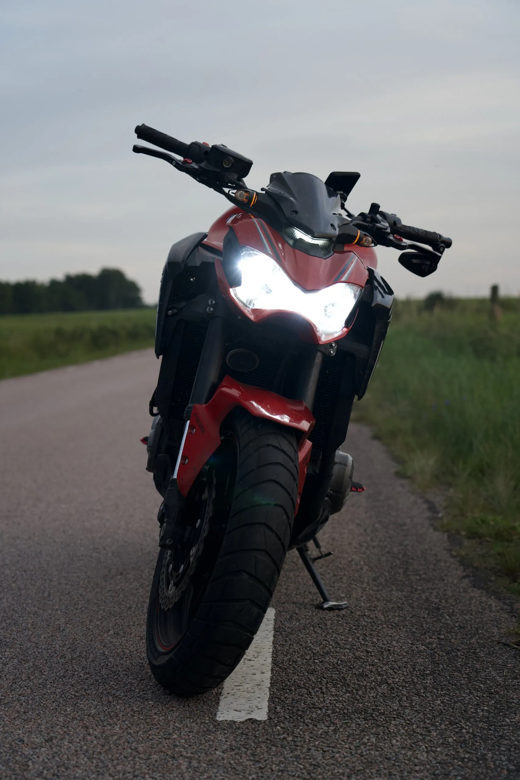 Kawasaki Z900 head on with its headlight on, on a country road